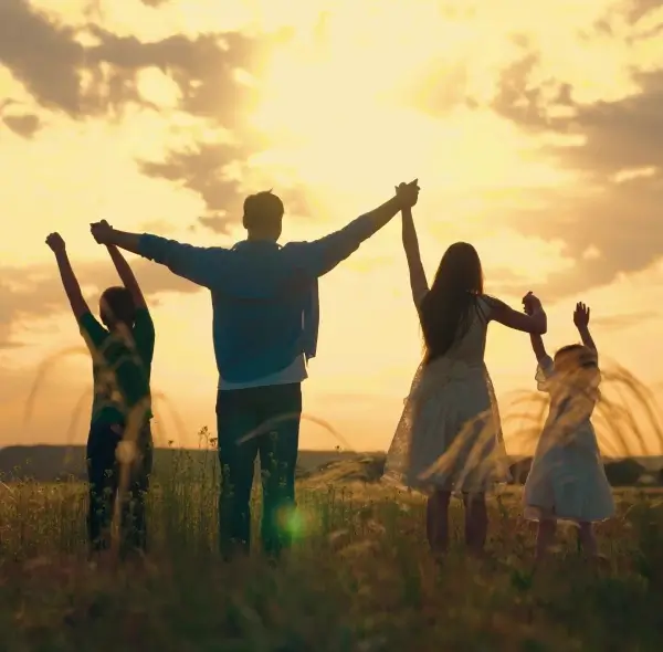 a group of people standing in a field with their arms raised